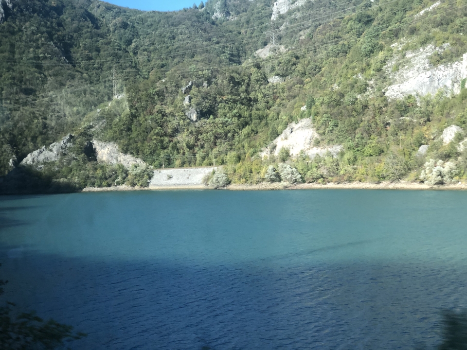 Blauw meer omringd door groene heuvels.