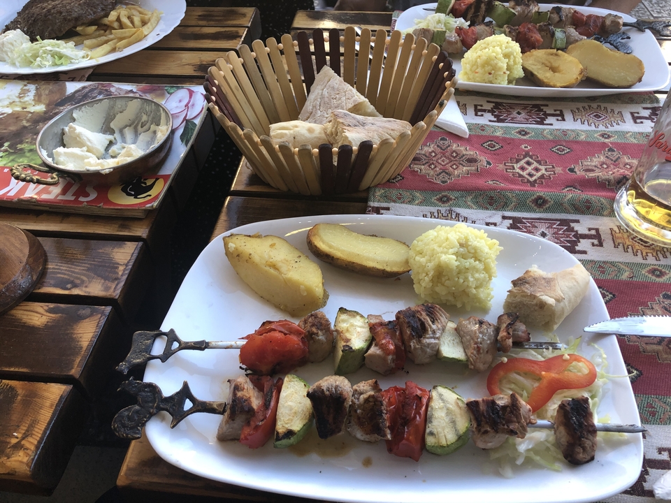 Plat traditionnel avec des brochettes et d'autres aliments dans une assiette.