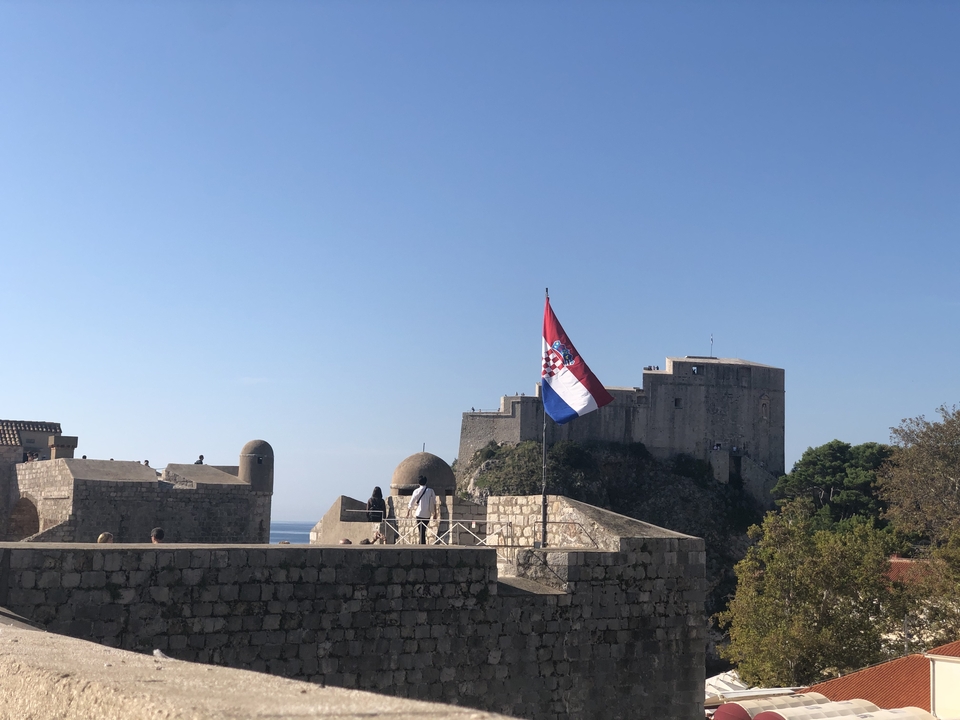 Forteresse surplombant la mer avec un drapeau.