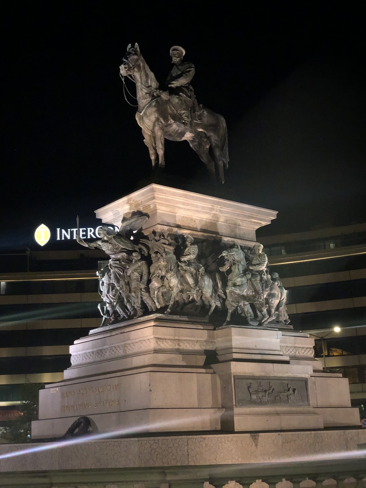 Monument avec statues historiques sous un ciel nocturne.