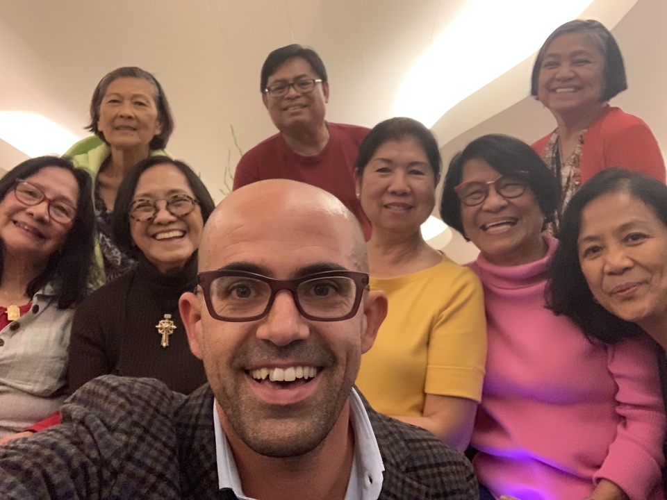 Selfie de groupe avec des personnes souriantes dans un cadre intérieur.