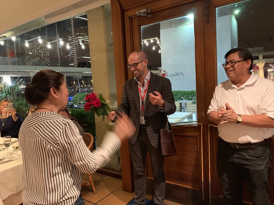 Deux personnes qui s'échangent des fleurs dans un restaurant.