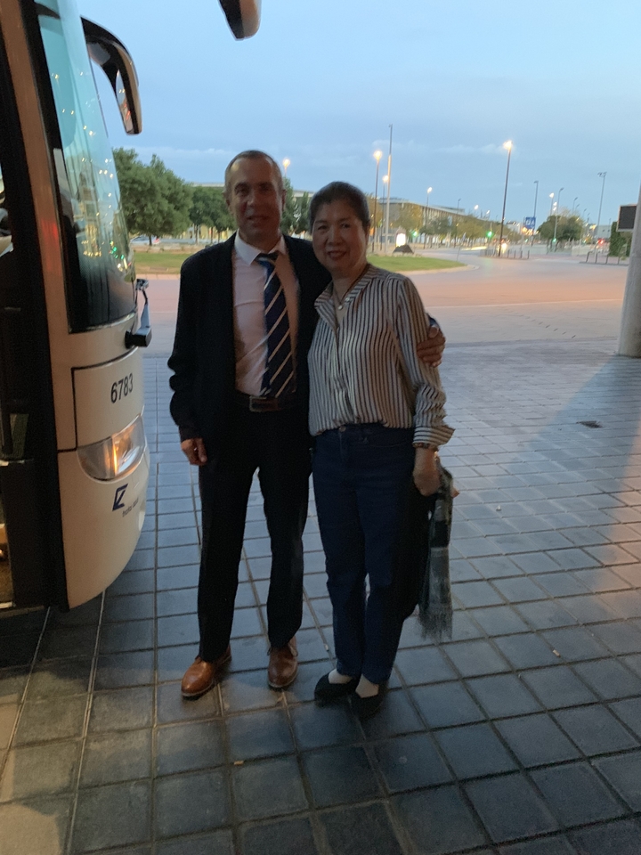 Deux personnes debout à côté d'un bus à l'extérieur.