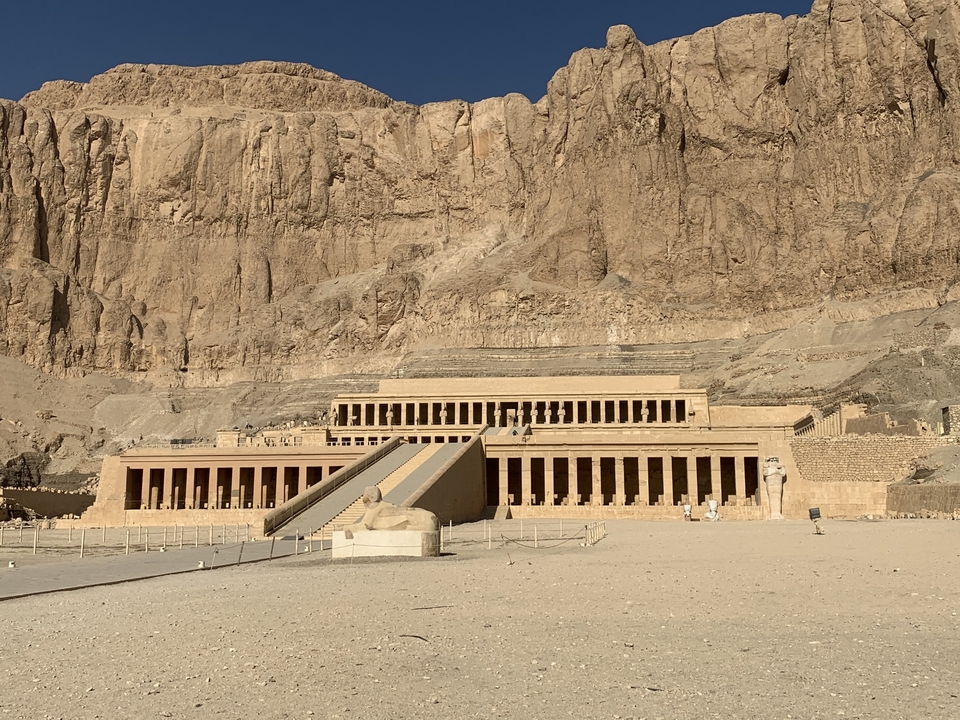 Temple égyptien antique avec colonnes sur fond rocheux.