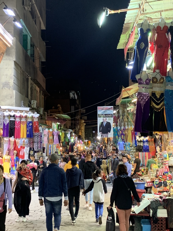 Marché nocturne animé avec des vêtements et décorations colorés.