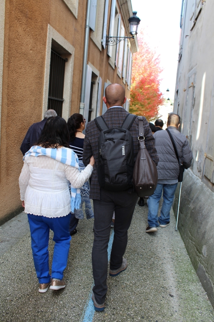 Des gens qui marchent dans une rue étroite.