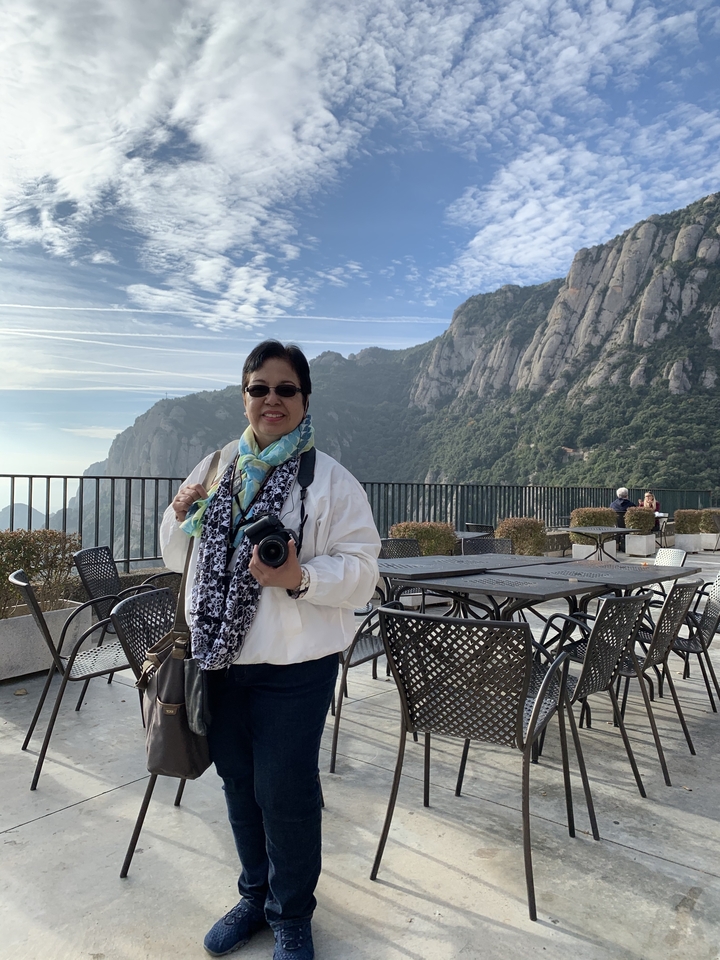 Personne posant sur une terrasse avec les montagnes de Montserrat en arrière-plan.