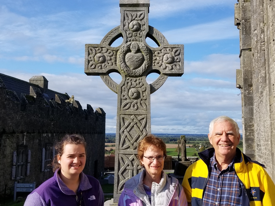 Group of people posing with a Celtic cross.