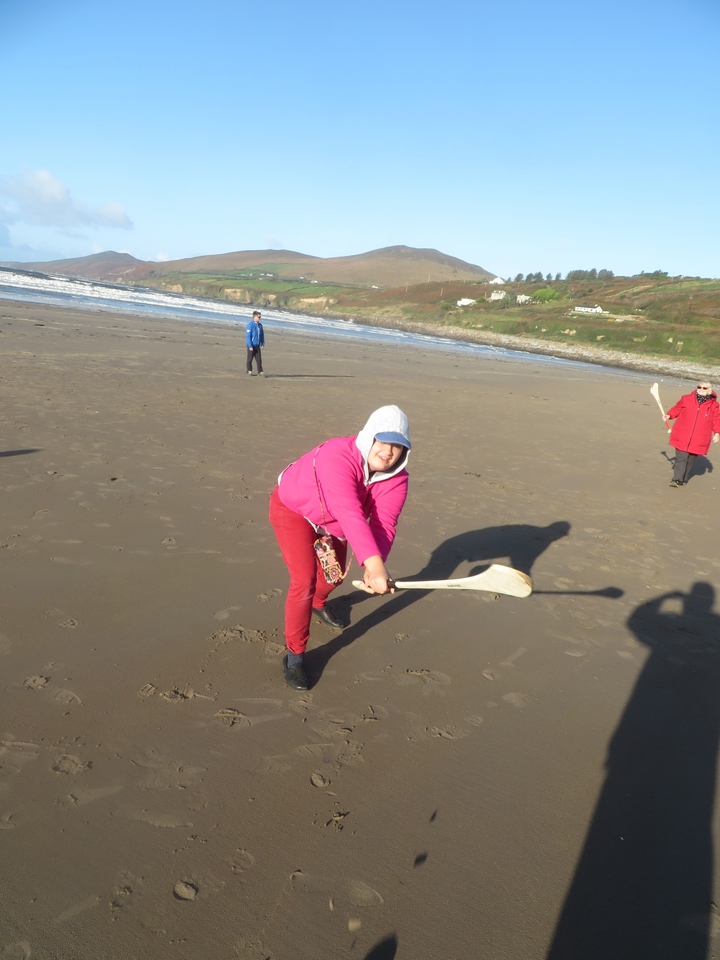 Des gens qui jouent au hurling sur une plage.