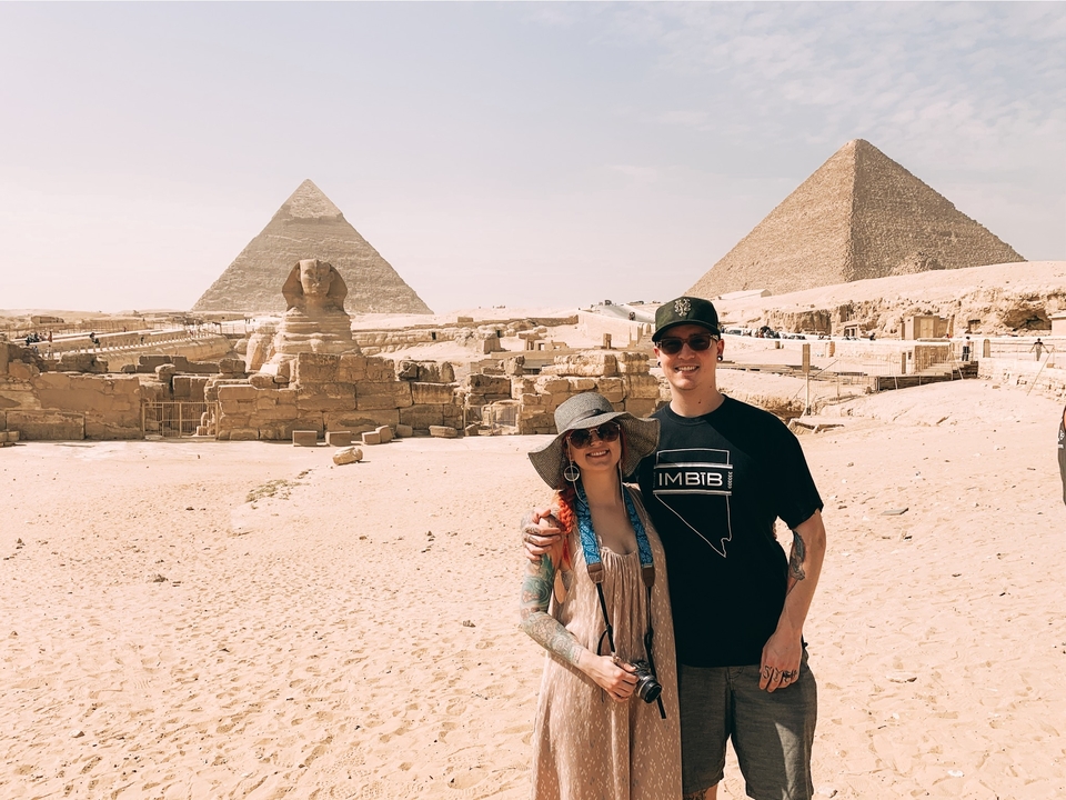 Couple posant devant le Sphinx et les Pyramides de Gizeh.