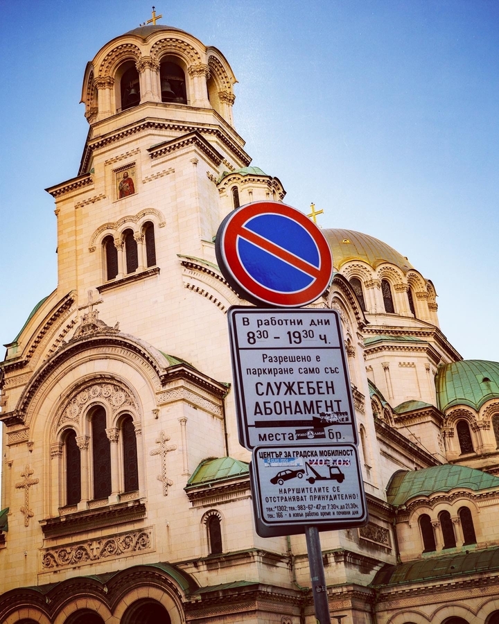Un panneau d'interdiction de stationner devant un dôme d'église orné.