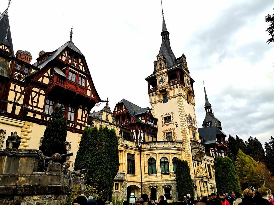 Château de Peles avec son architecture ornée et les arbres environnants.