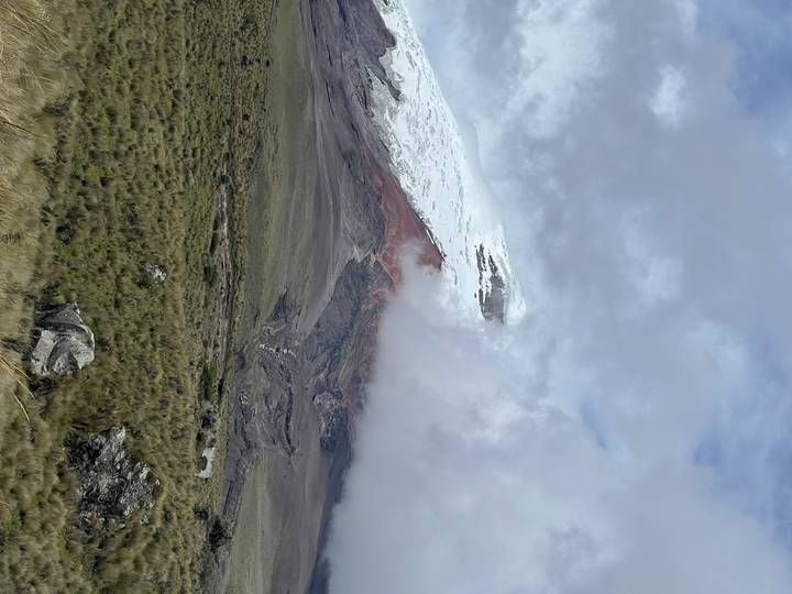 Un sommet enneigé partiellement couvert de nuages.