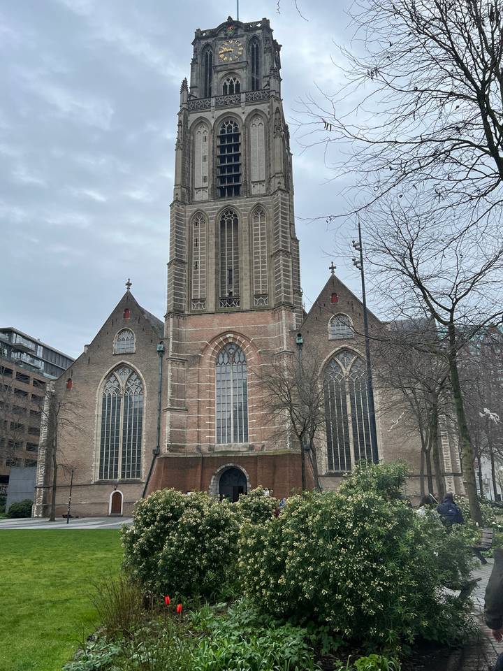 Une église avec une haute tour et des vitraux.