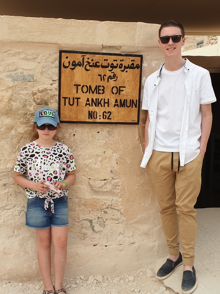 Deux personnes posant près d'un panneau pour la Tombe de Toutânkhamon