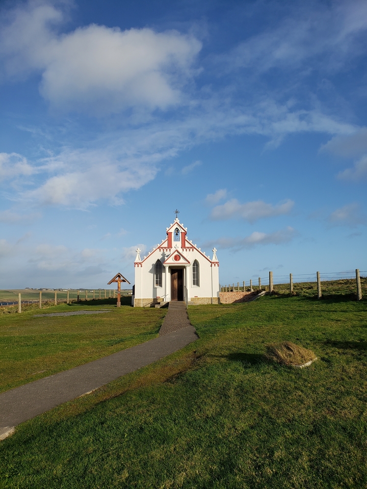Petite chapelle entourée d'herbe et d'une clôture
