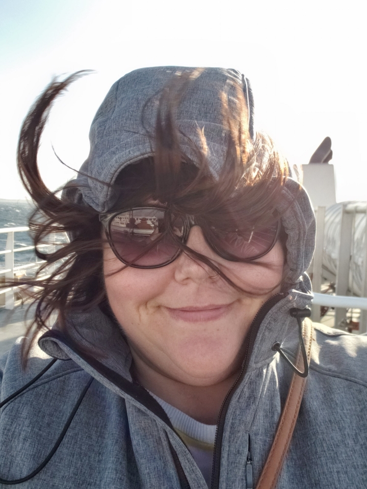 Personne sur le pont venteux d'un ferry portant des lunettes de soleil