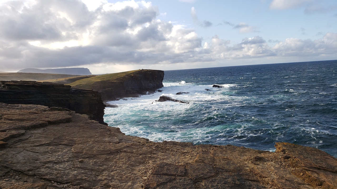 Falaises et vagues océaniques sous un ciel nuageux