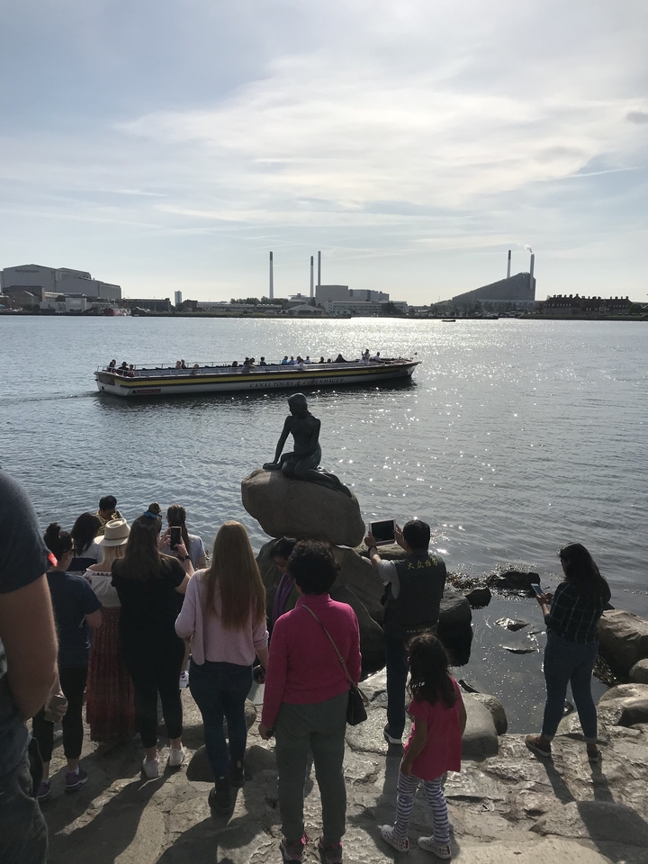 Des gens se sont rassemblés autour d'une statue célèbre près de l'eau.