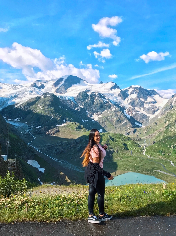 Une personne qui pose devant une magnifique chaîne de montagnes.