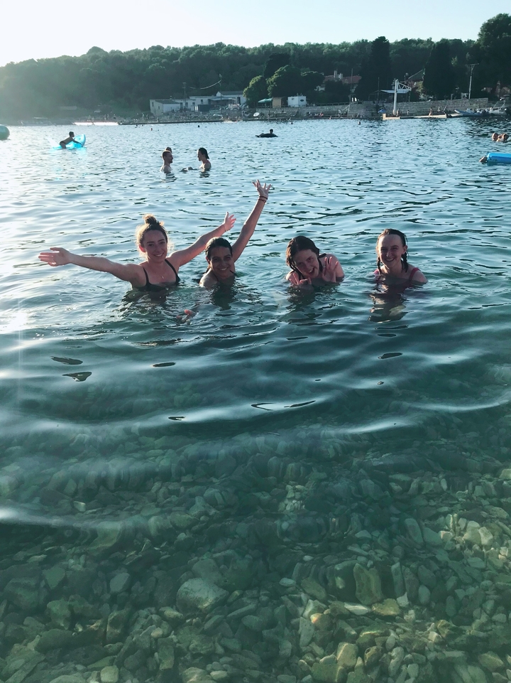 Quatre personnes profitant d'une baignade dans une eau claire.