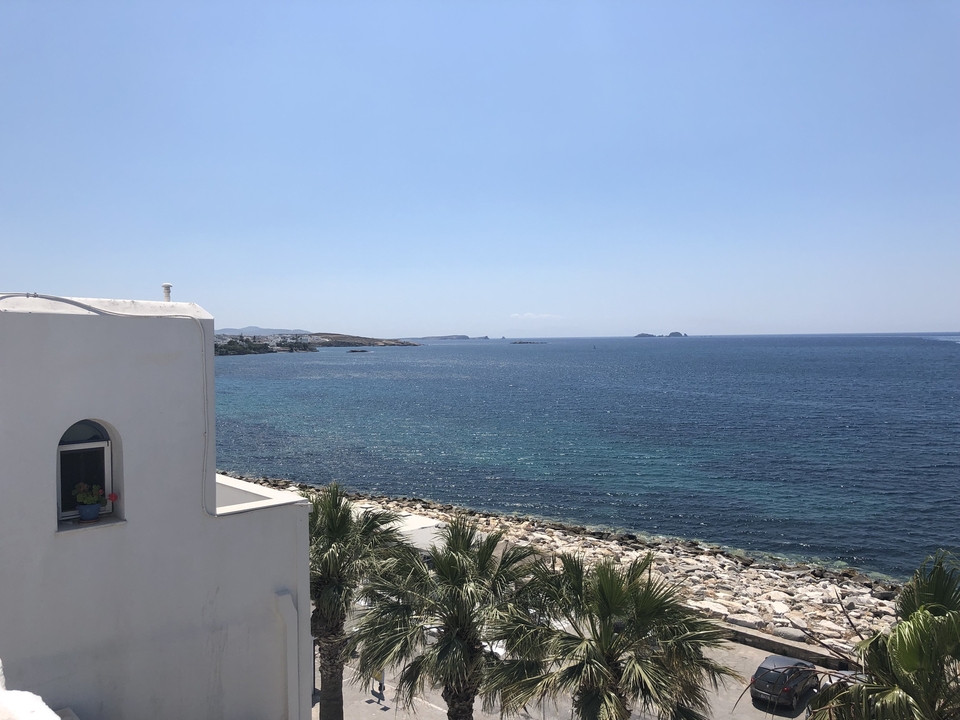 Vue sur l'océan depuis le balcon d'un bâtiment blanc.