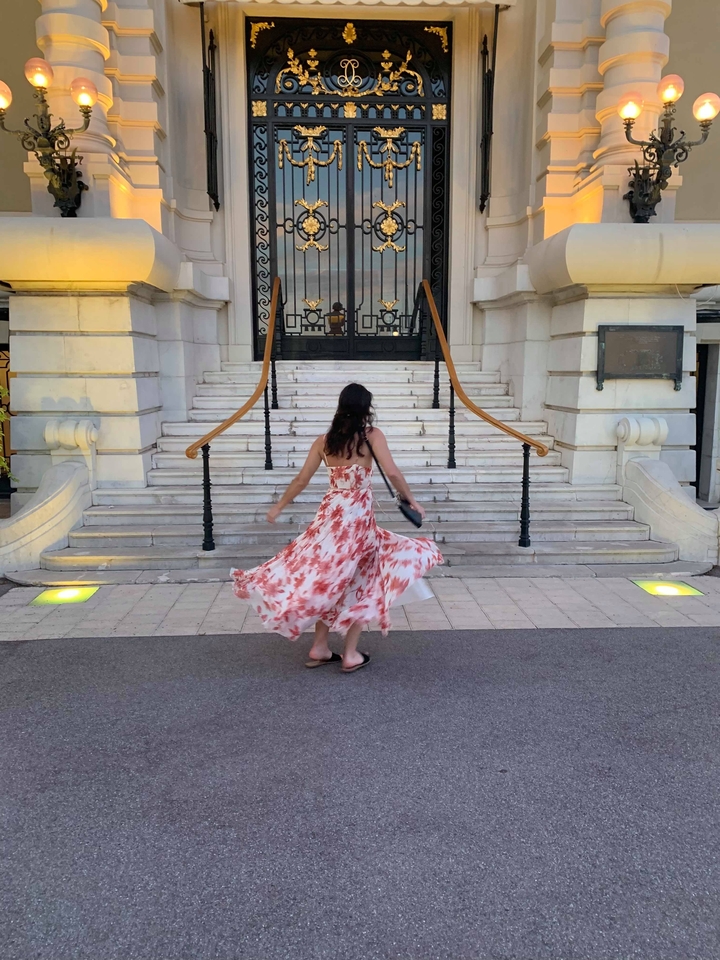 Personne qui tournoie dans une robe sur le trottoir devant des marches.