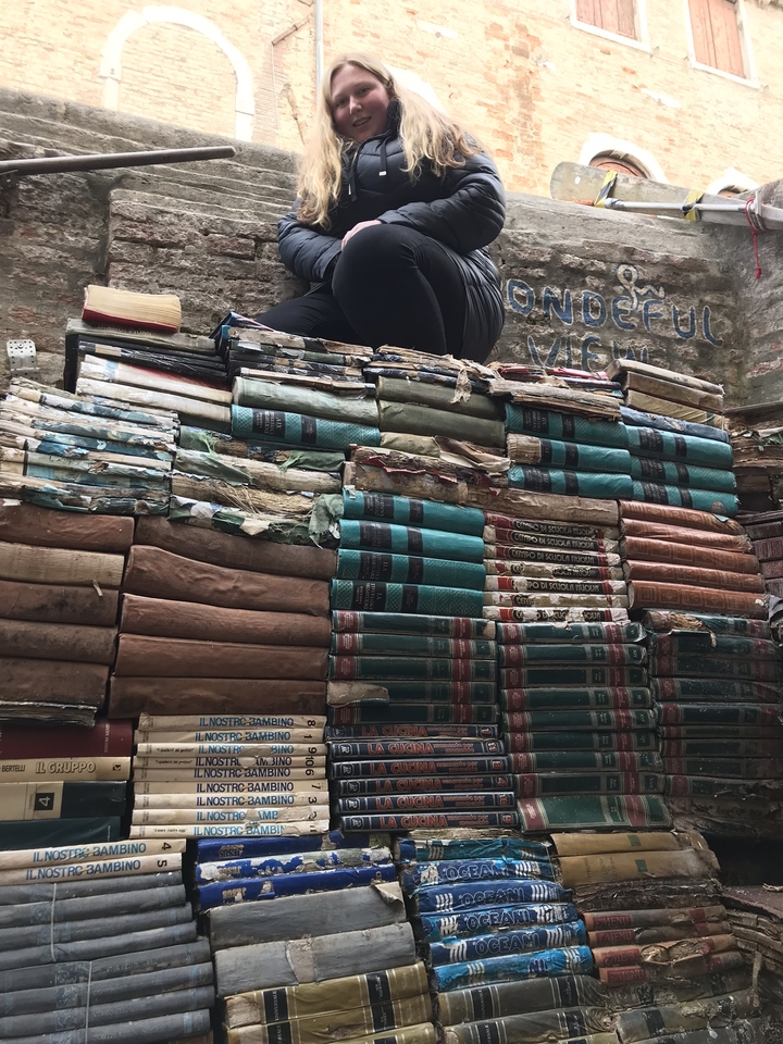 Pile de vieux livres contre un mur.