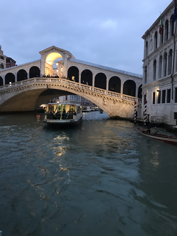 Bateau sous le pont du Rialto sur un canal de Venise.