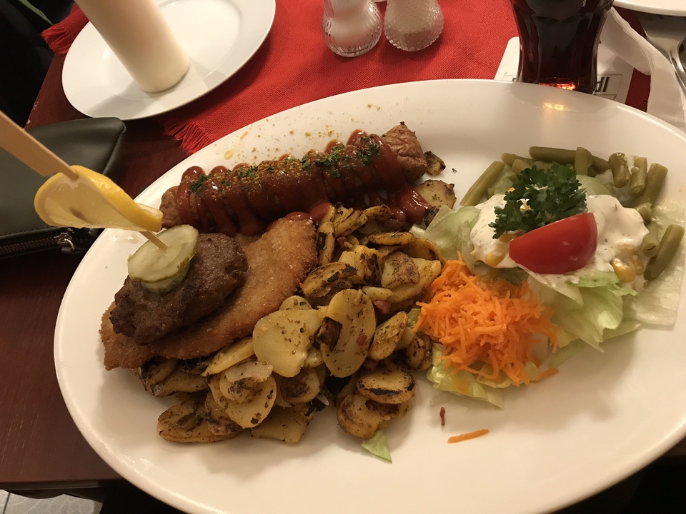 Assiette avec saucisses, pommes de terre et salade.