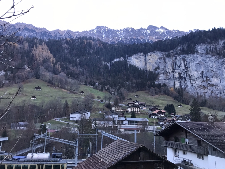 Vue panoramique d'une région montagneuse avec des maisons dispersées.