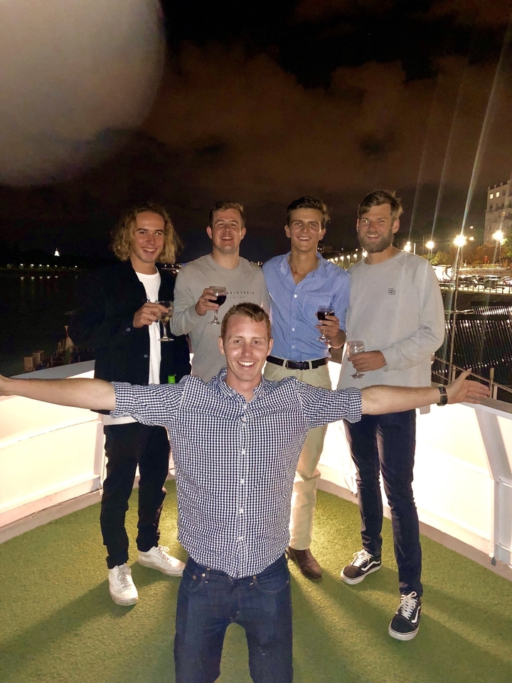 Groupe d'amis posant la nuit avec des cocktails.