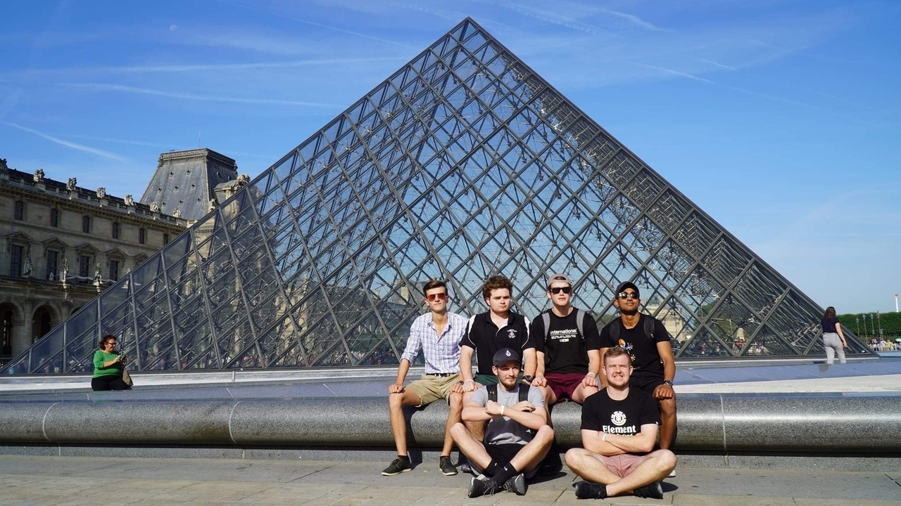 Groupe posant au Louvre avec la Pyramide.
