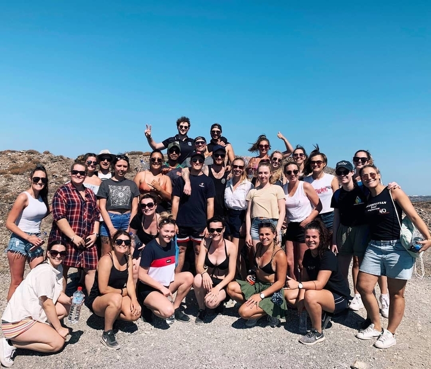 Un groupe de personnes qui posent à l'extérieur sous un ciel dégagé.