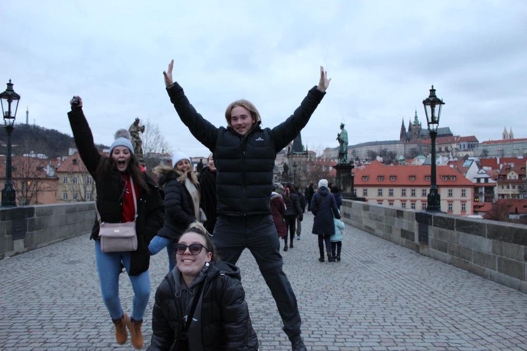 Groupe de personnes profitant de la vue sur le pont Charles, Prague.