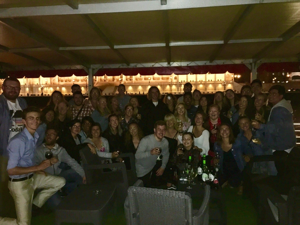 Photo de groupe dans un espace extérieur faiblement éclairé avec un bâtiment en arrière-plan.