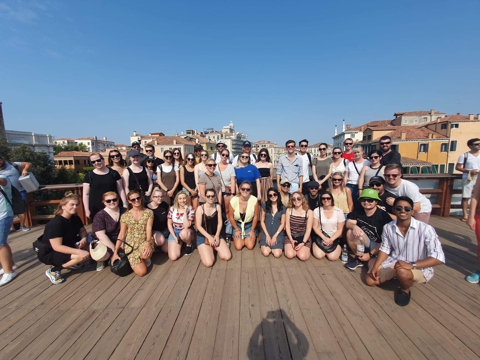 Photo de groupe sur un pont dans une zone urbaine ensoleillée.