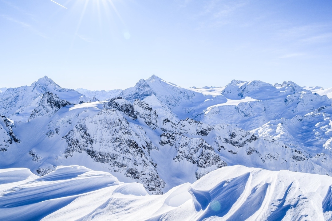 Snow-covered mountain range with clear blue skies.