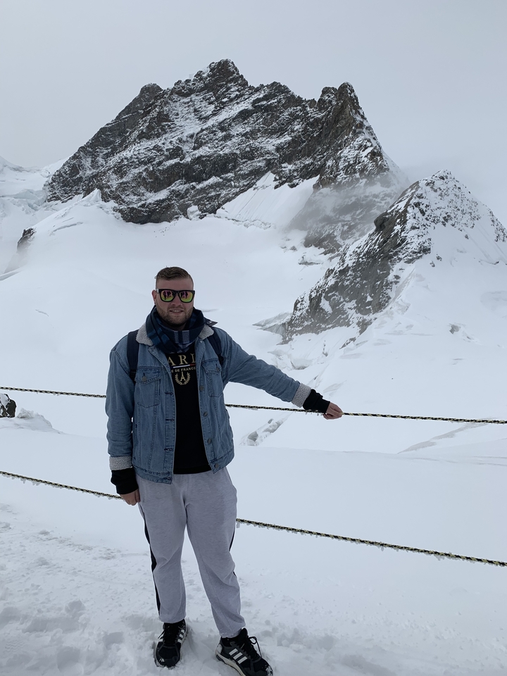 Personne debout dans un paysage de montagne enneigé.