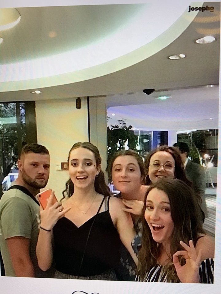 Un groupe de personnes à l'intérieur souriantes face à la caméra.