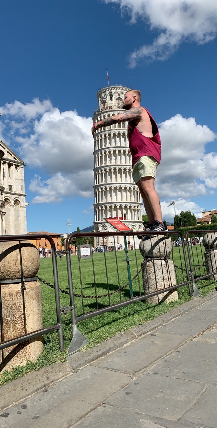 Personne posant avec humour avec la Tour de Pise.