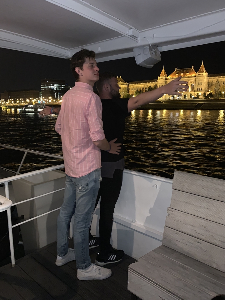 Deux personnes imitant une scène sur un bateau pendant une croisière nocturne.