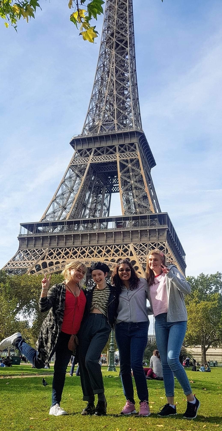 Groupe de personnes posant avec la Tour Eiffel en arrière-plan
