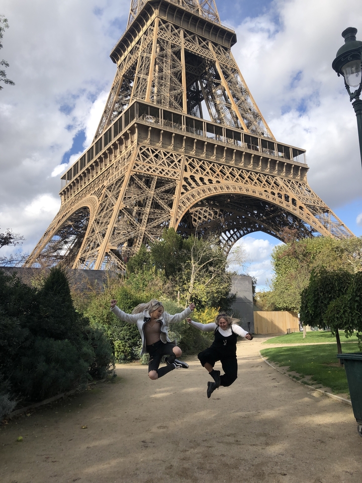 Deux personnes sautant devant la tour Eiffel à Paris.