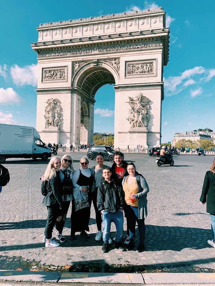 Photo de groupe devant l'Arc de Triomphe à Paris.