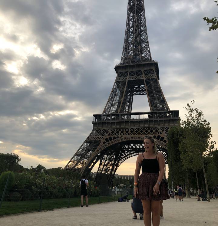 Person posing in front of the Eiffel Tower.
