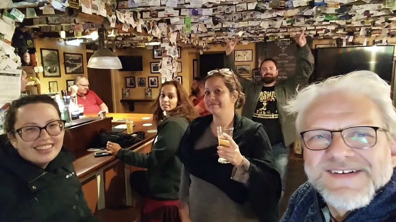 Groupe de personnes à l'intérieur d'un décor de pub chaleureux.