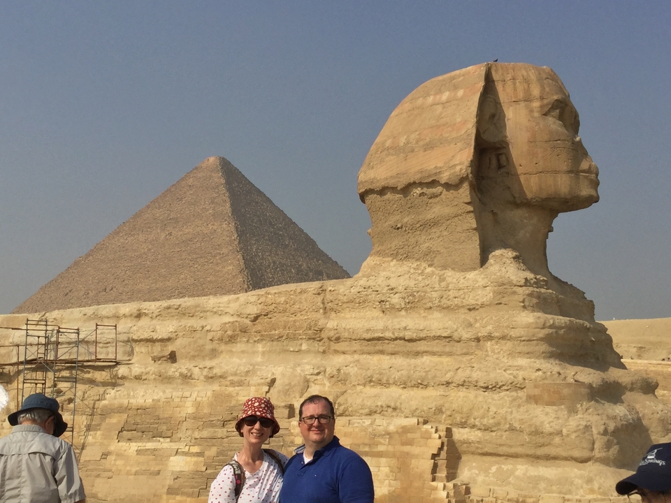 Deux personnes devant le Sphinx et une pyramide.