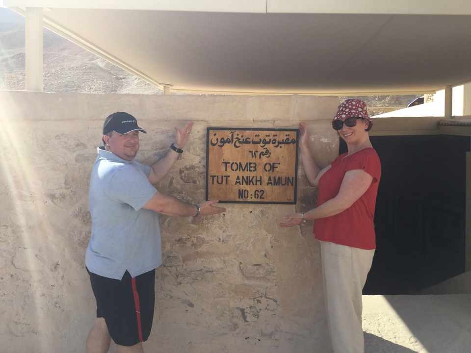 Deux touristes pointant vers un panneau indiquant « Tombeau de Toutânkhamon ».