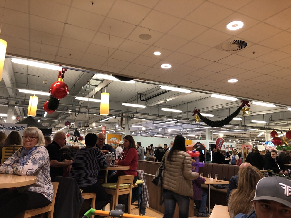 Aire de restauration bondée avec des gens qui mangent et socialisent.